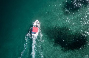 Aerial shot of a motorboat moving forward in the sea A little motorboat moving forward in the sea shot from above